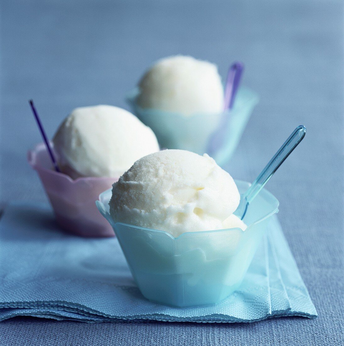 Yoghurt ice cream in three pastel-coloured bowls