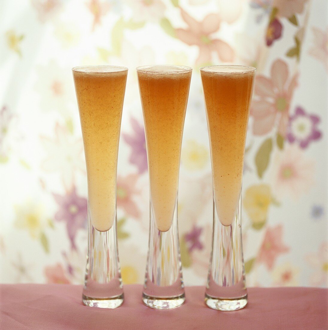 Three glasses of Bellini (sparkling wine with peach juice)