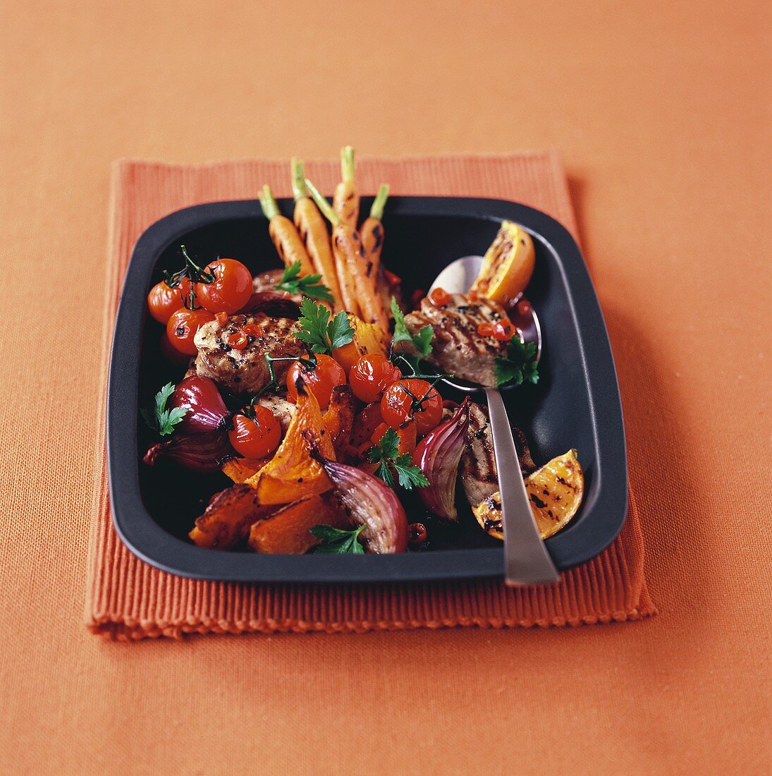 Grilled pork medallions with vegetables and oranges