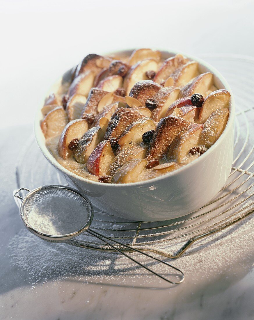 'Log pyre' (bread pudding) with apples, raisins & icing sugar