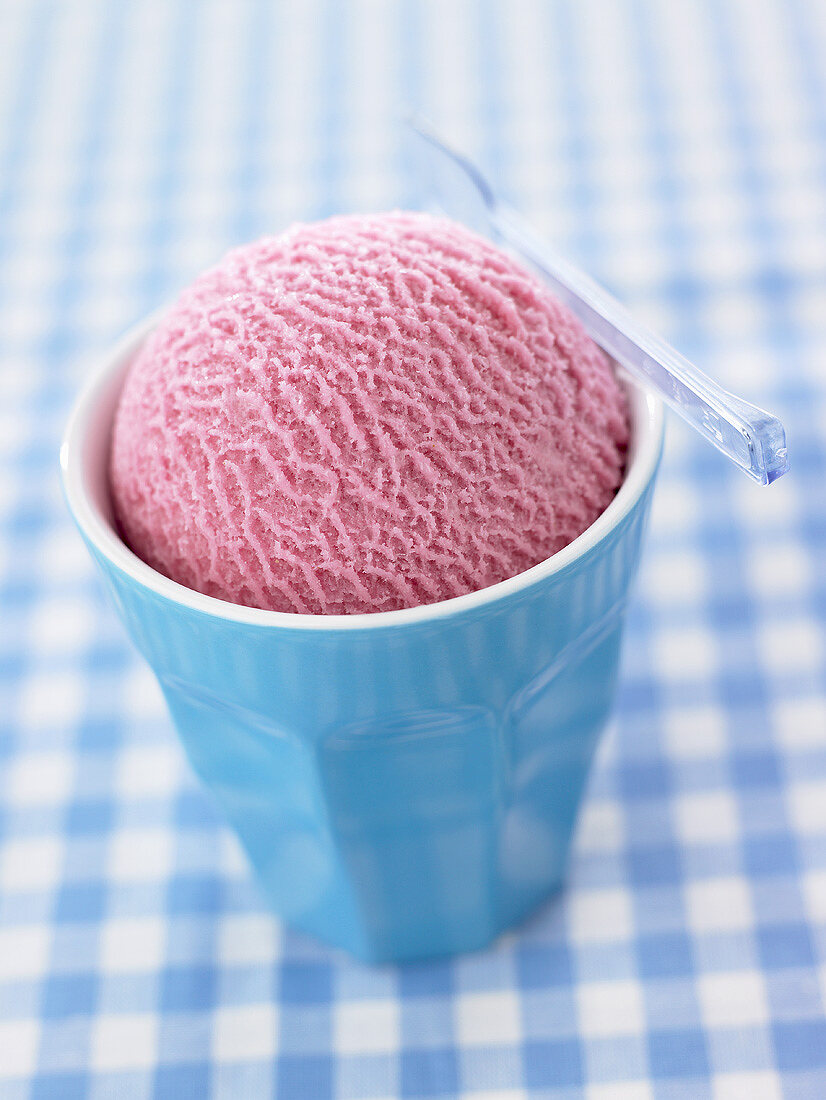 A scoop of raspberry ice cream in a beaker
