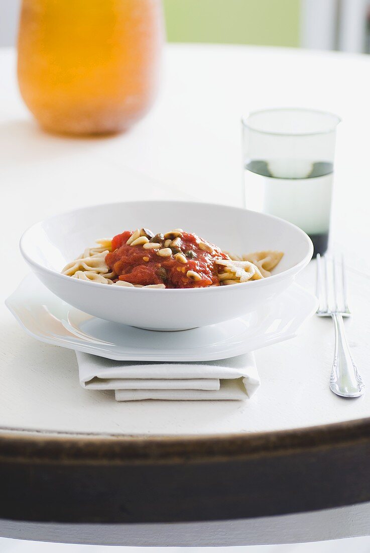 Vollkornfarfalle mit Tomatensugo, Kapern und Pinienkernen