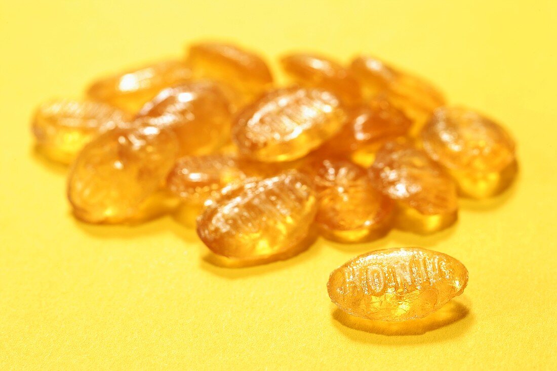 Mehrere Honigbonbons auf gelbem Hintergrund