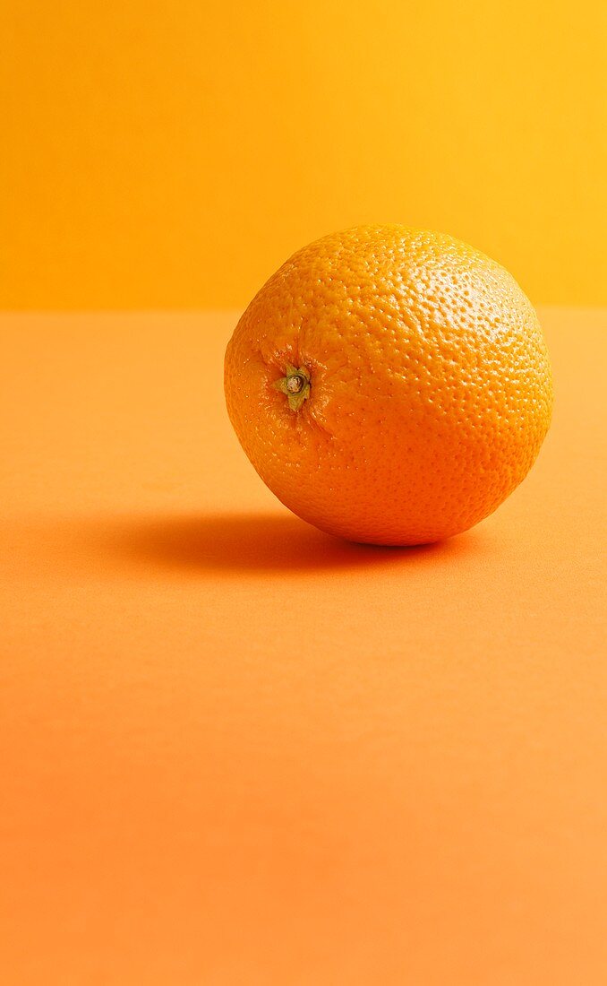 Eine Orange auf orangefarbenem Hintergrund