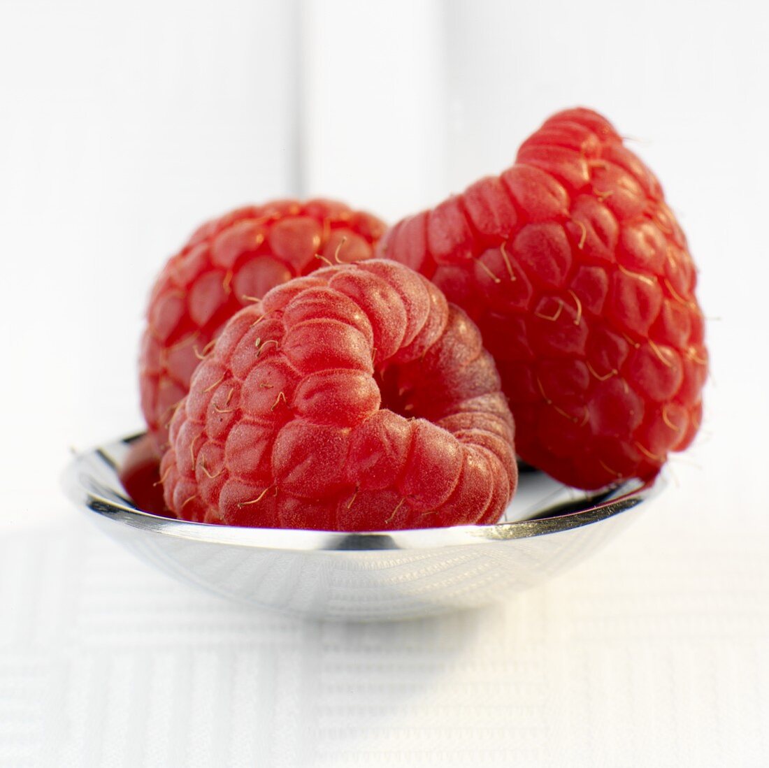 Three raspberries on spoon (close-up)
