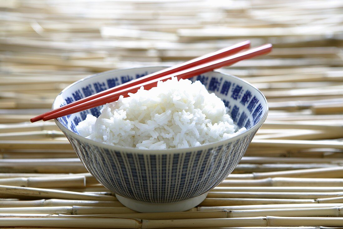 Reis in asiatischer Schale mit Essstäbchen