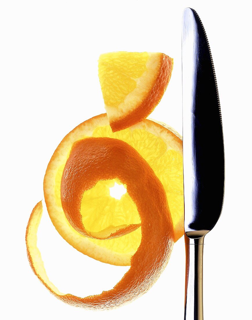 Orangenscheibe und Orangenschale mit Messer