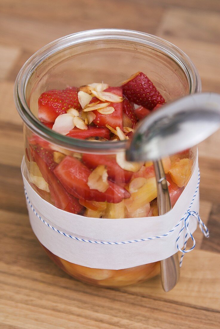 Fruit salad with flaked almonds in a glass