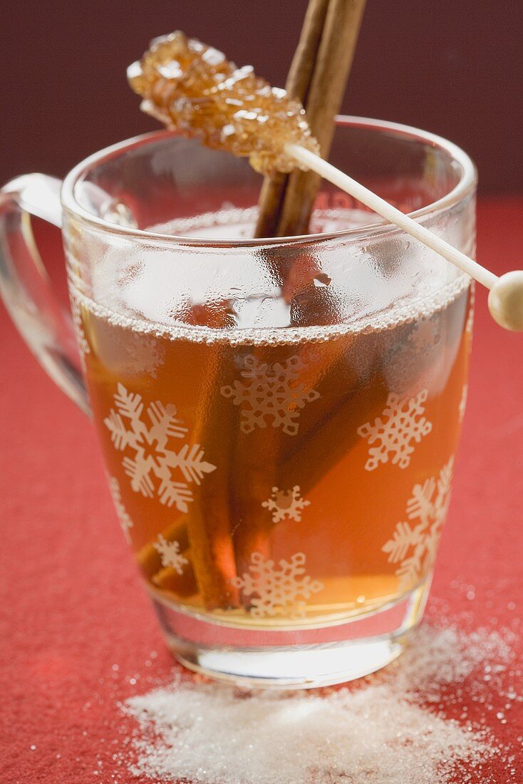 Glass of winter tea with cinnamon sticks & sugar swizzle stick