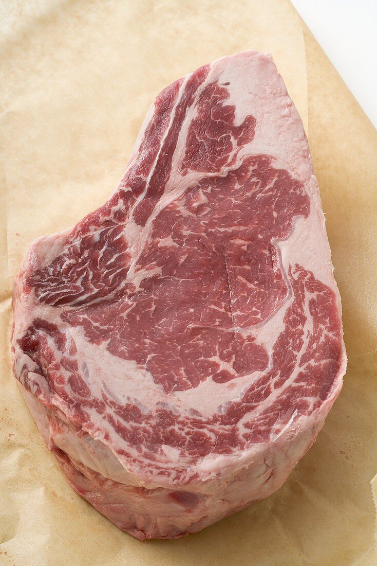 Raw beef steak on greaseproof paper