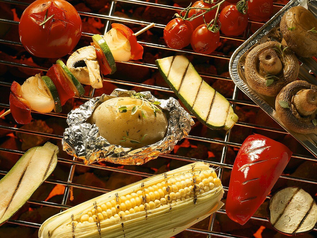 Vegetables, mushrooms and corn on the cob on a barbecue
