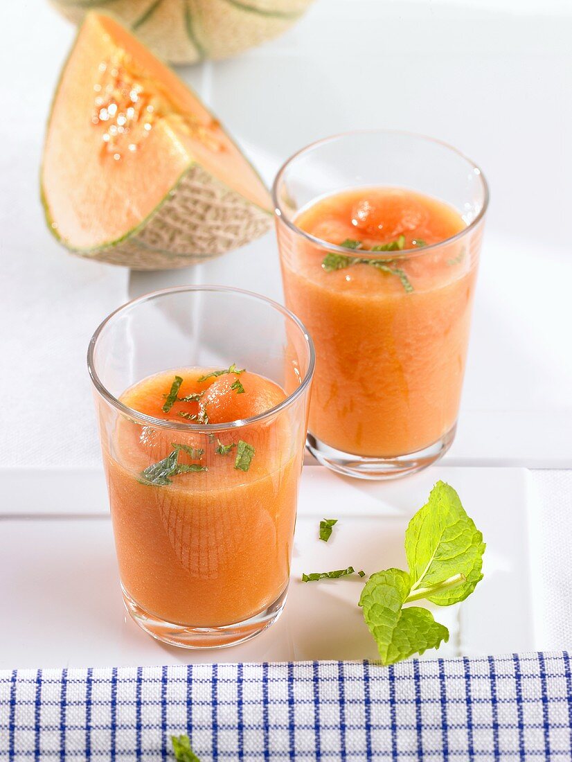 Melonenkaltschale mit Melonenkugeln und Minze in Gläsern