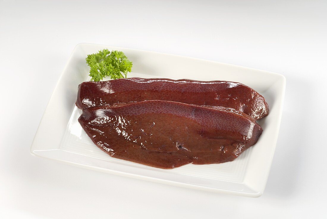 Two slices of pig's liver on rectangular plate