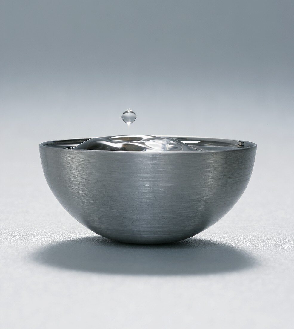 Drop of water over metal bowl