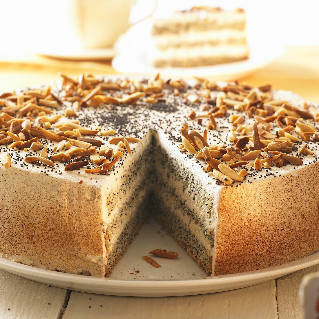 Poppy seed cake with slivered almonds, a piece removed