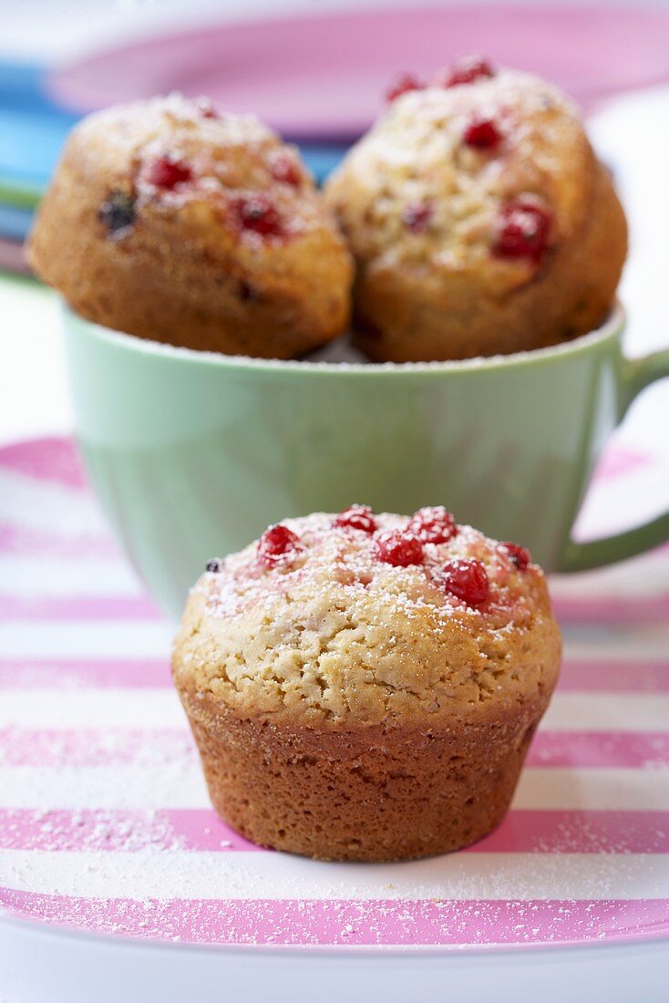 Redcurrant muffins in and in front of a cup