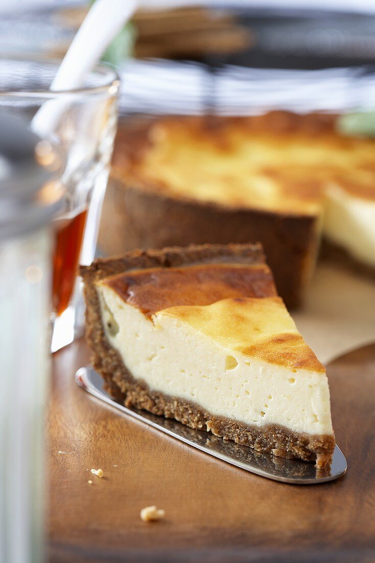 Piece of cheesecake in front of cake with piece removed