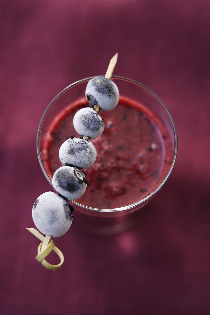 Blueberry smoothie with frozen blueberry skewer