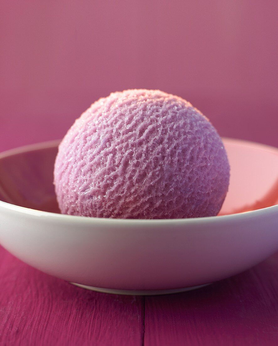 A scoop of blueberry ice cream in a bowl