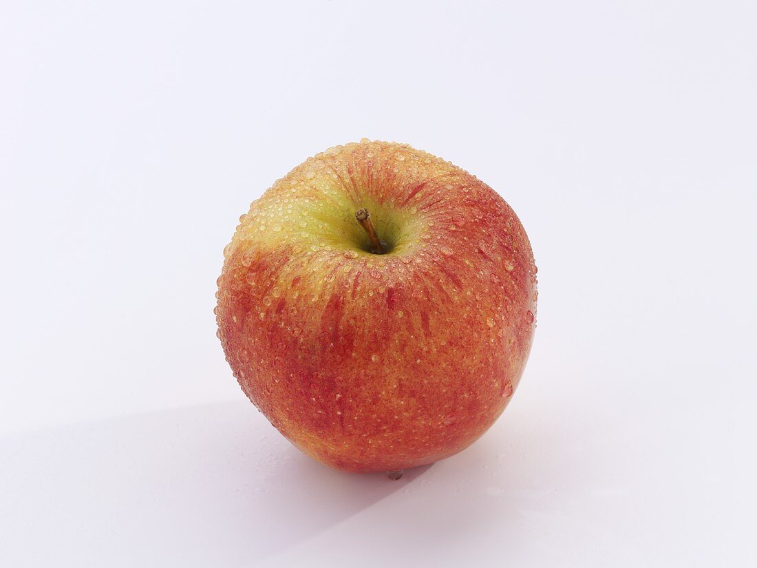 A Gala apple with drops of water