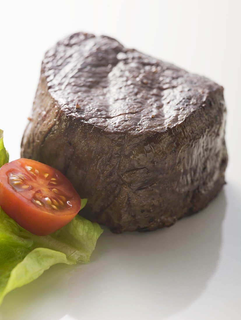 Beef fillet garnished with cherry tomato and lettuce leaf