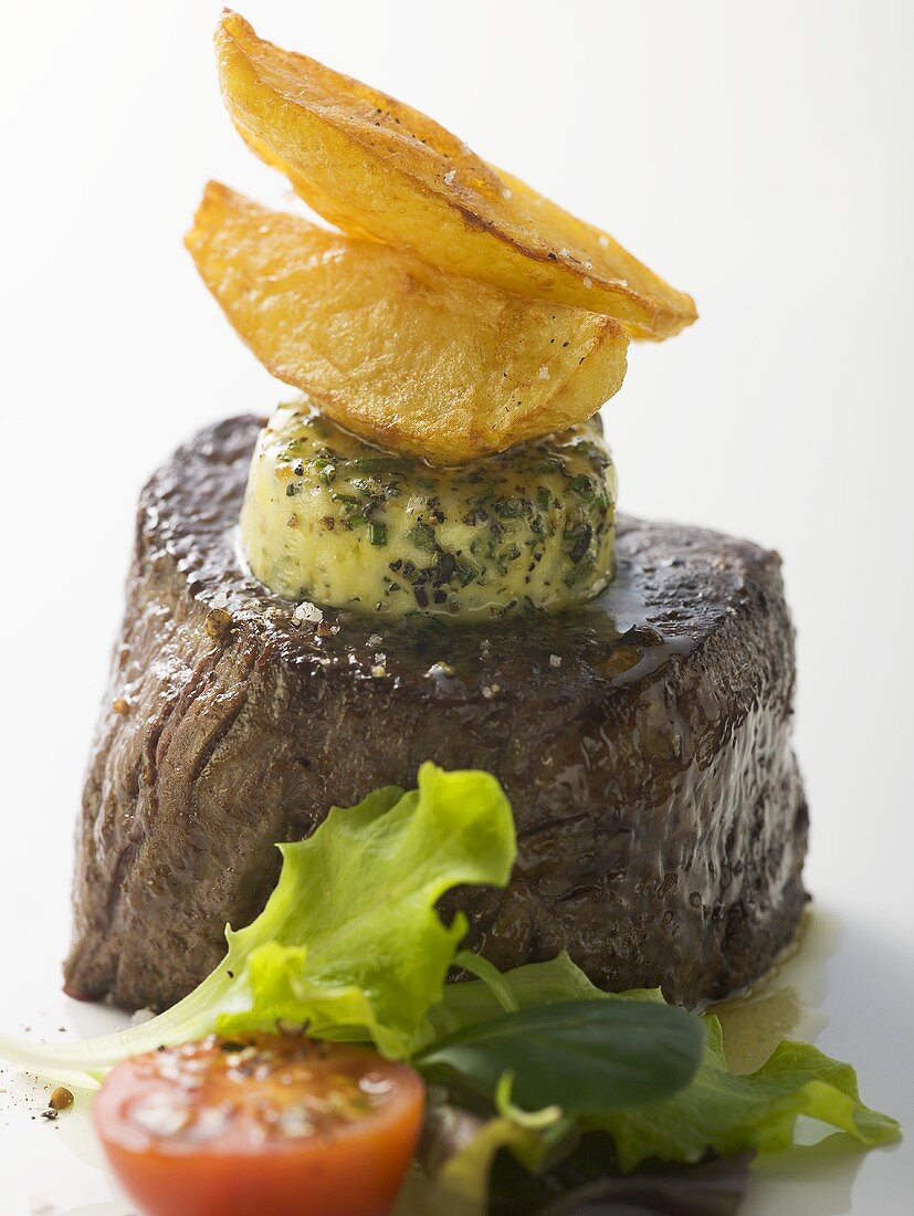 Beef fillet with herb butter, potato wedges, salad garnish