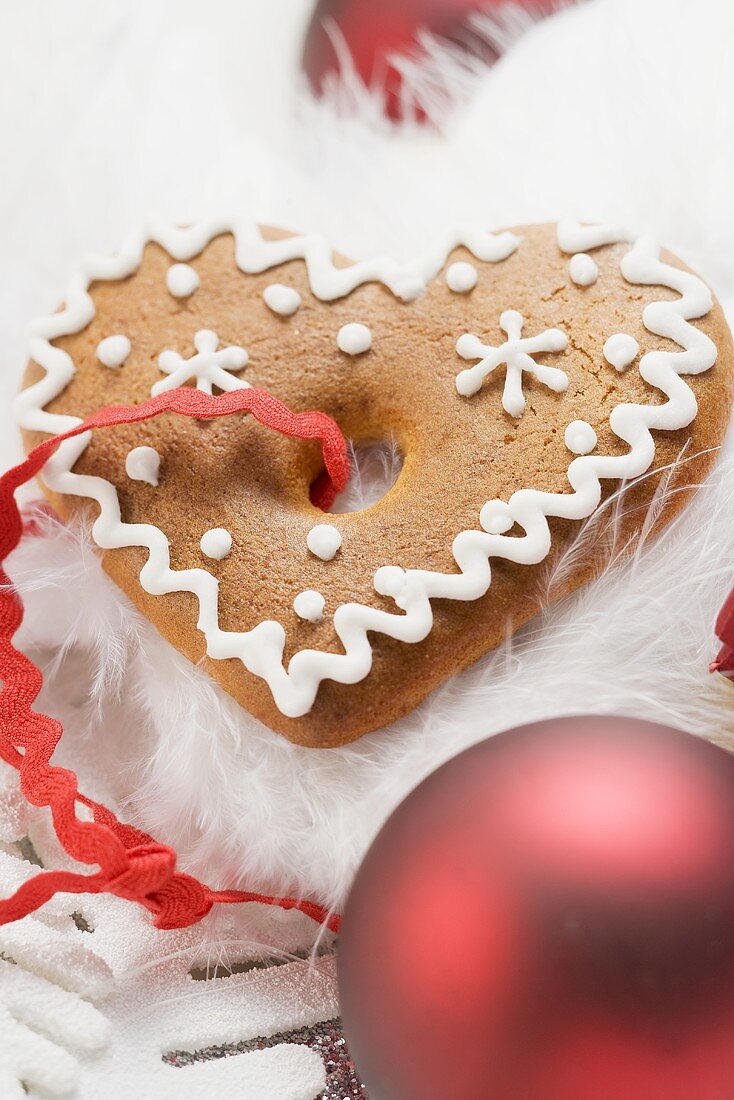 Lebkuchenherz, umgeben von Weihnachtsdeko