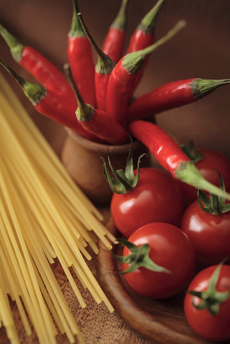 Stillleben mit Tomaten, Chilischoten und Spaghetti