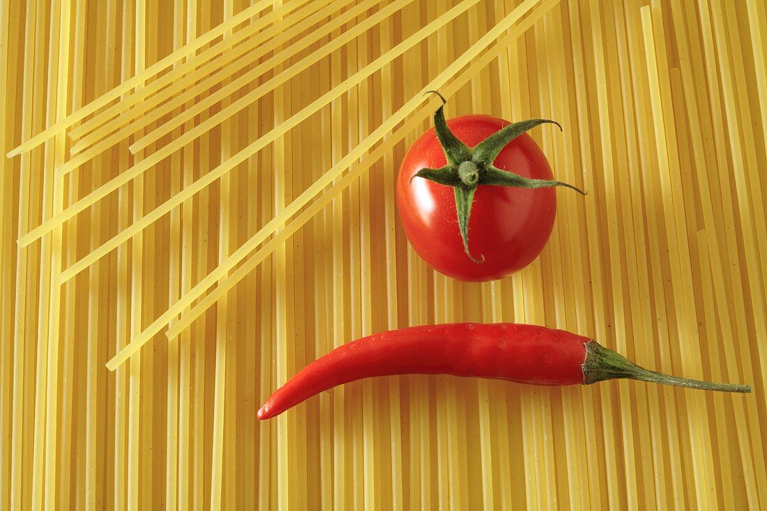 Tomate und Chilischote auf Spaghetti