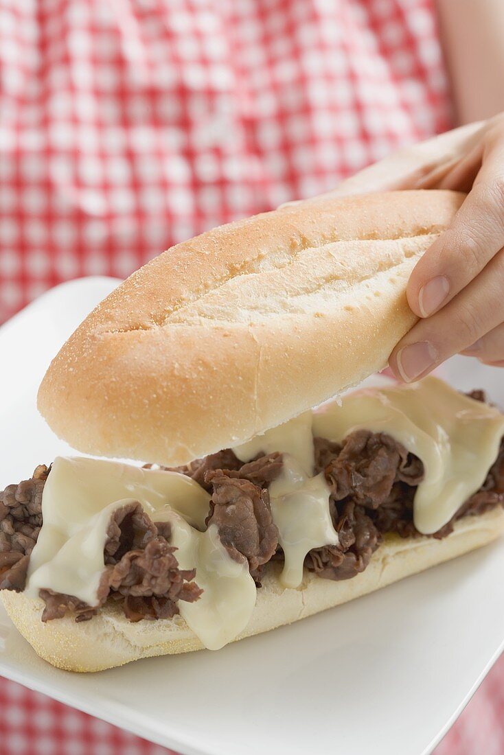 Woman holding bacon and cheese sandwich