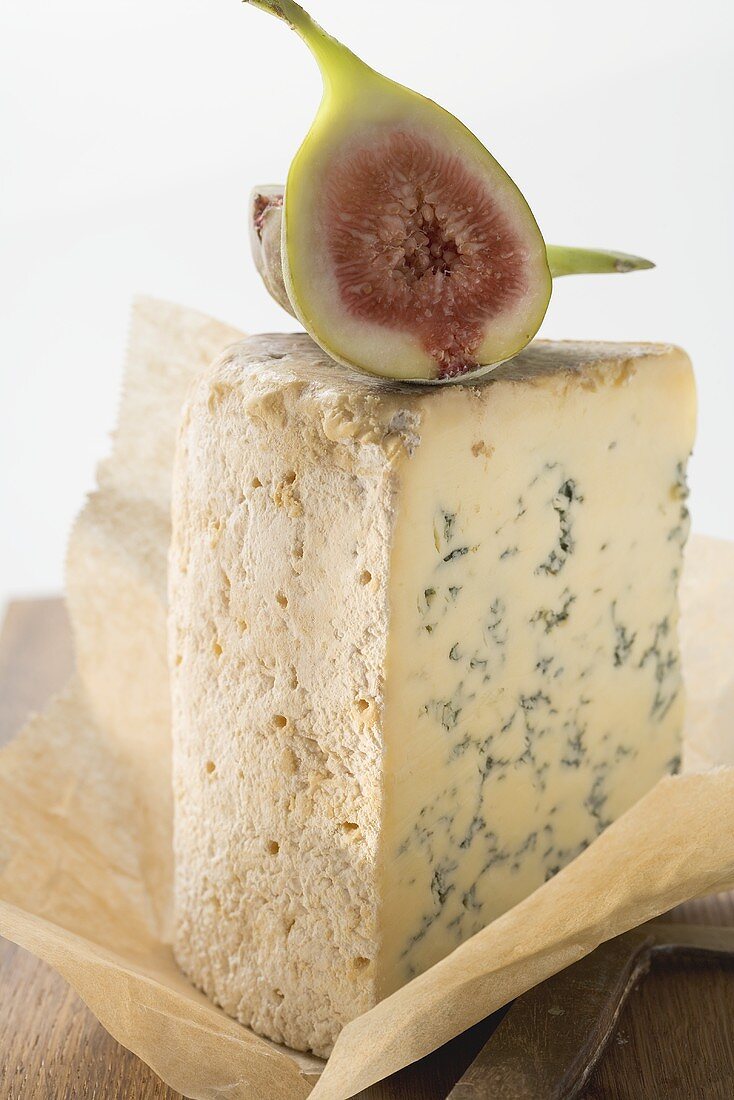Piece of Stilton with fresh fig on paper
