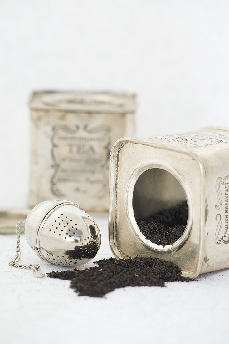 Two tins of black tea and tea infuser