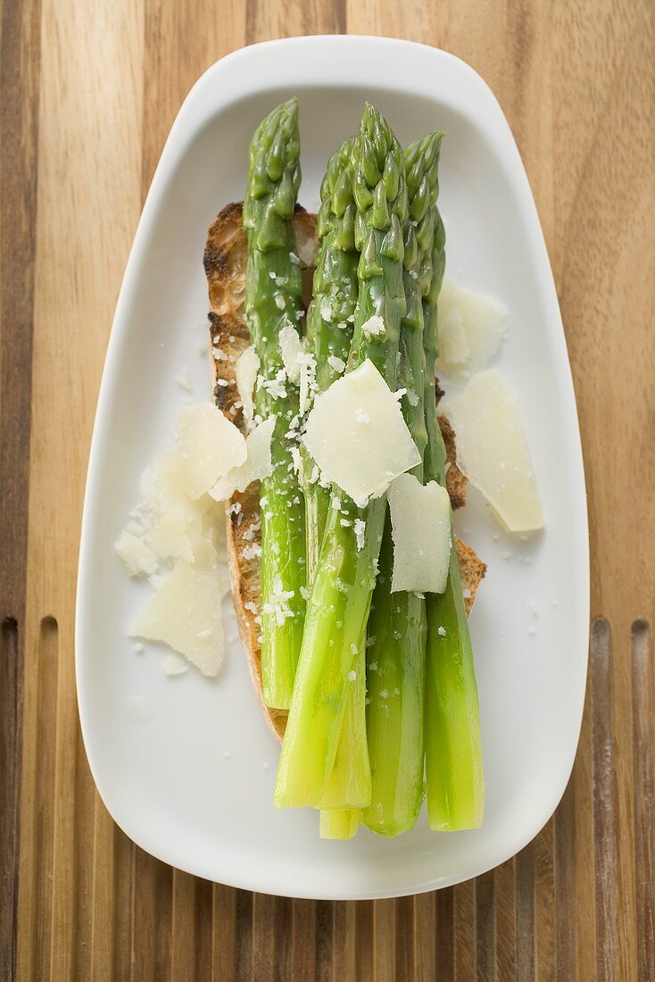 Grüner Spargel mit Parmesan auf Röstbrot (Draufsicht)