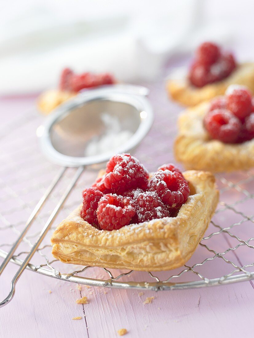 Raspberry puff pastry tarts with sugar on cake rack