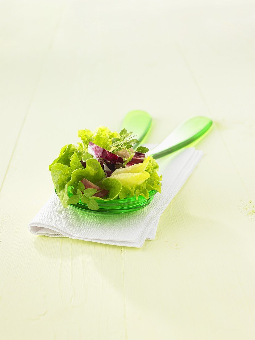 Mixed salad leaves on salad servers
