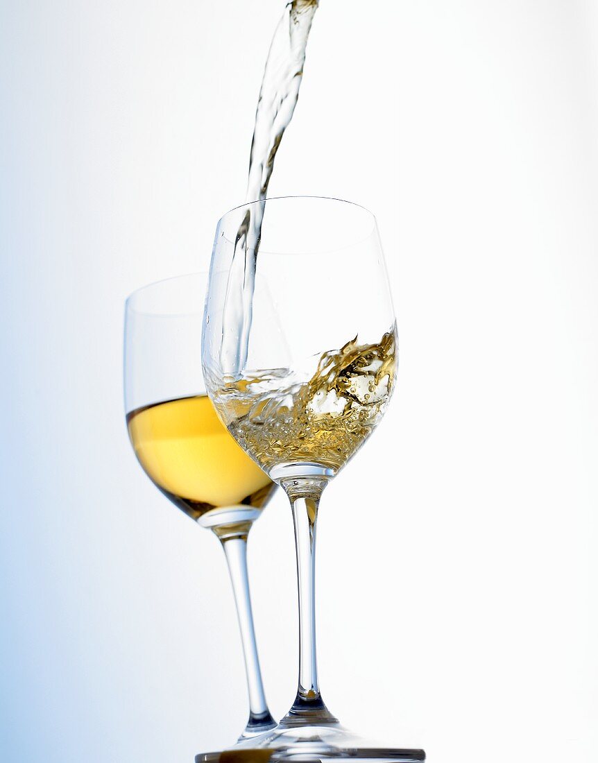 Weißwein in Glas einschenken