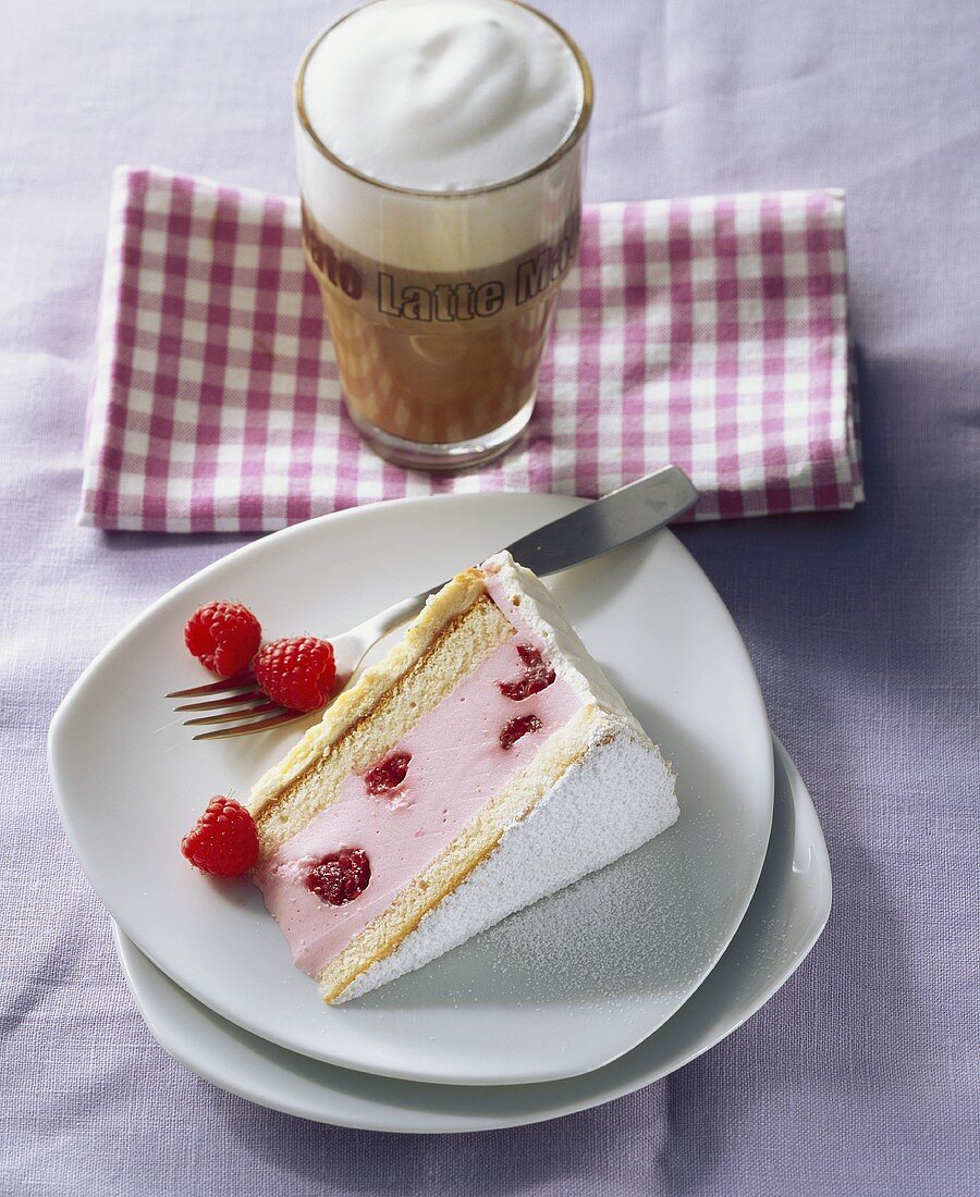A piece of raspberry yoghurt cake with coffee