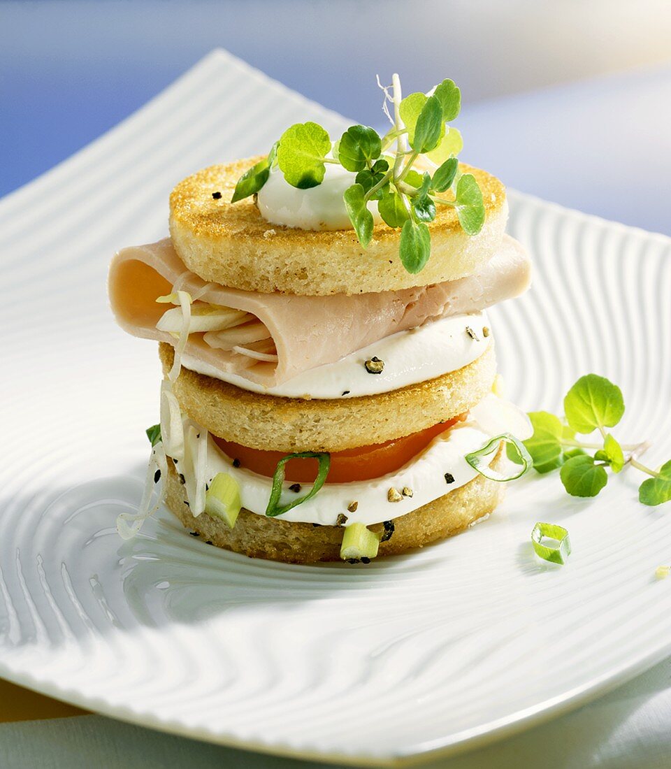 Turm aus Toastbrot, Frischkäse, Tomate und Schinken