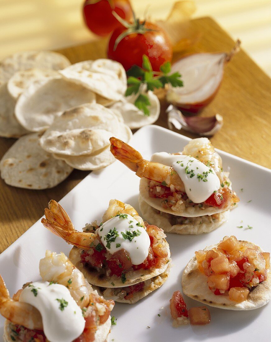 Mini-tortillas topped with tomatoes, prawns & soft cheese