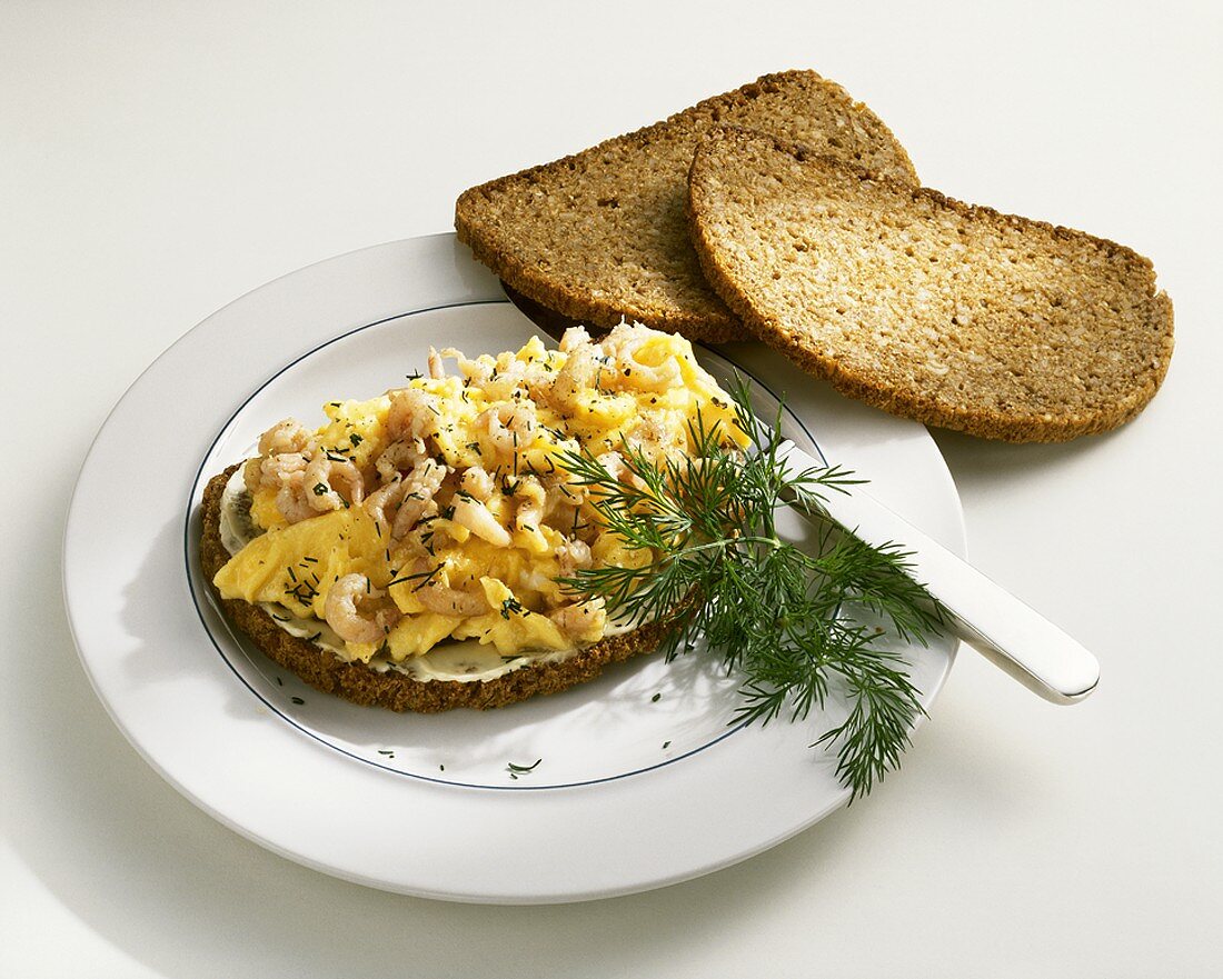 Bread topped with scrambled egg and shrimps
