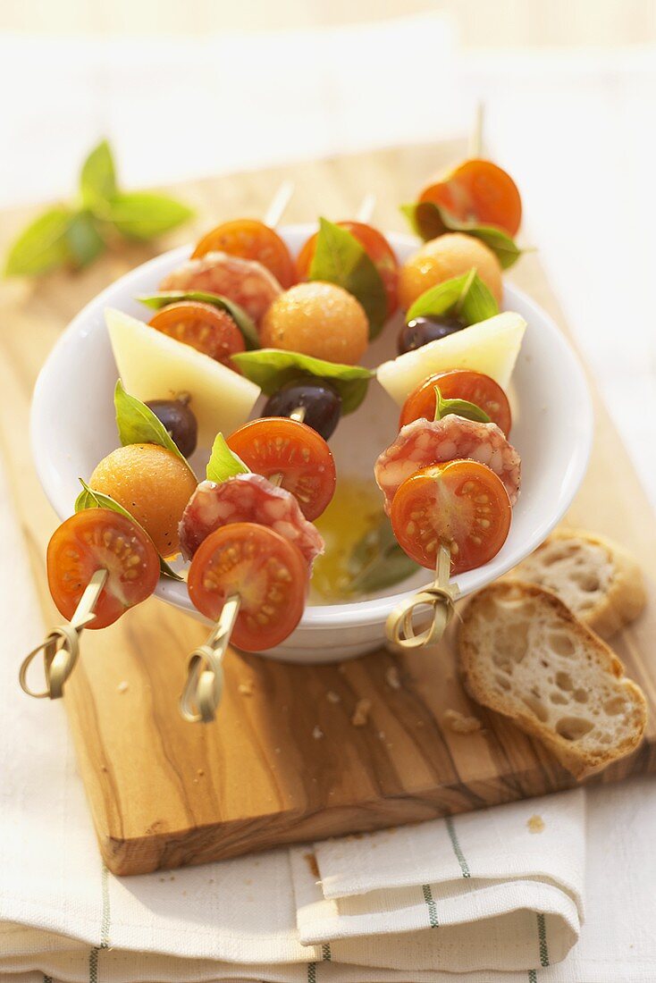Tomatoes, cheese, sausage and melon on skewers