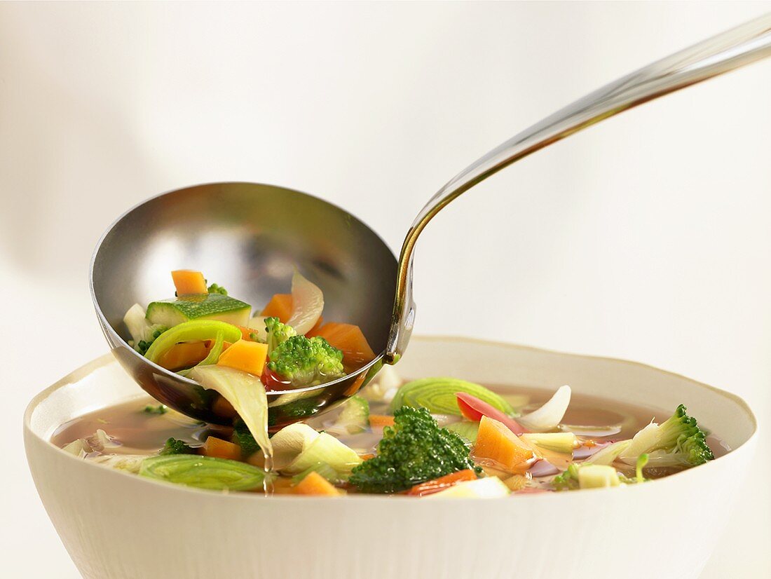 Vegetable soup in bowl and ladle