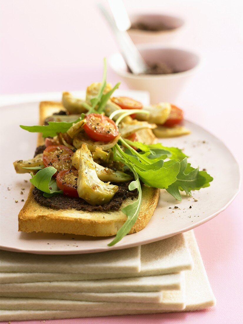 Olive paste, vegetables and rocket on toast