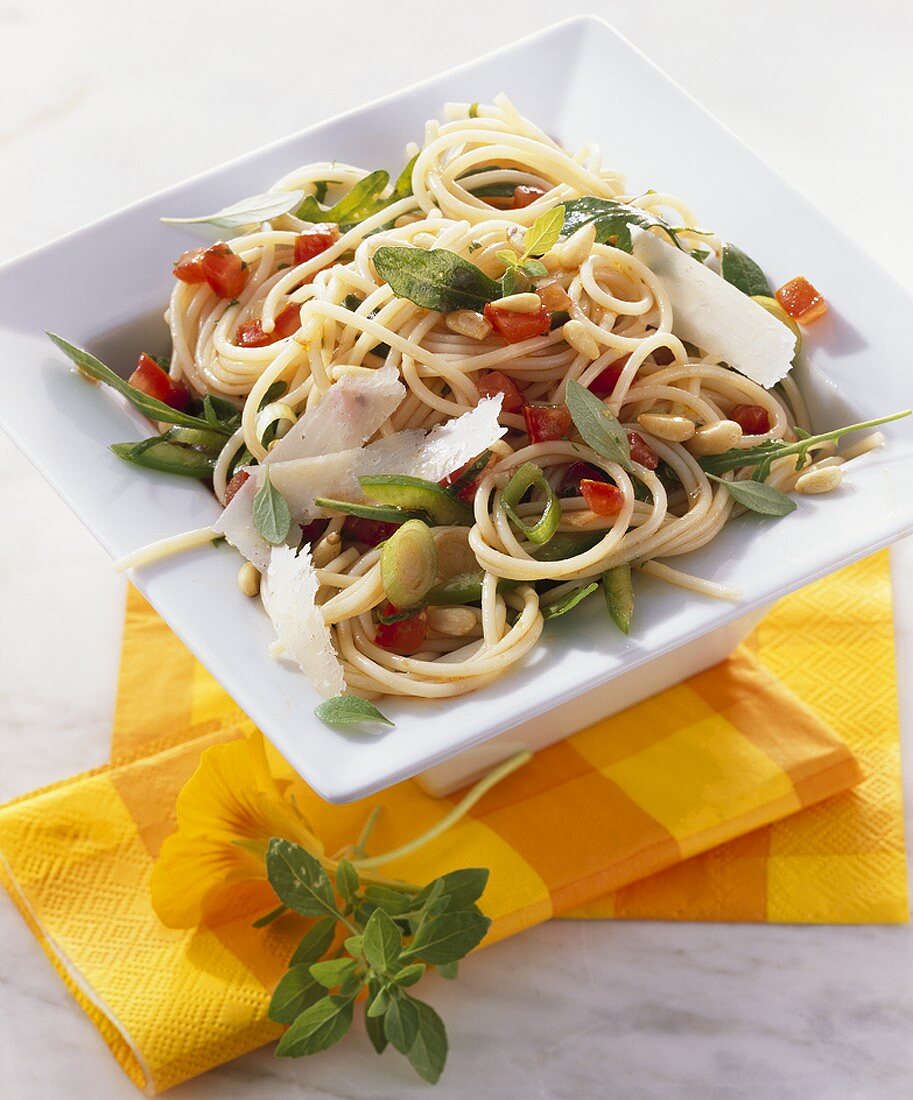 Spaghetti salad with vegetables, rocket and pine nuts