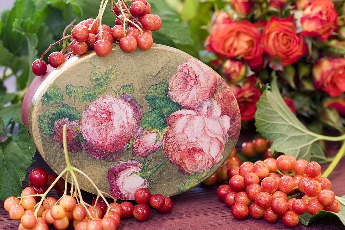 Nostalgic box with old roses, guelder rose berries