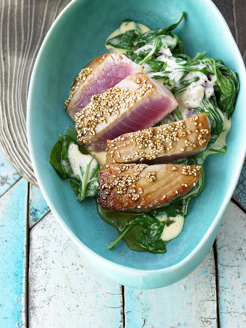 Tuna steaks with sesame seeds on spinach
