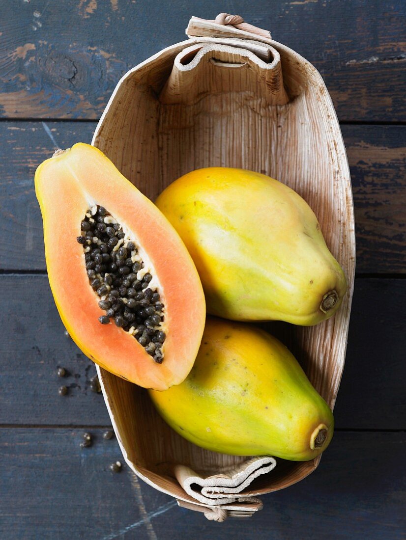 Papayas, whole and halved, in basket