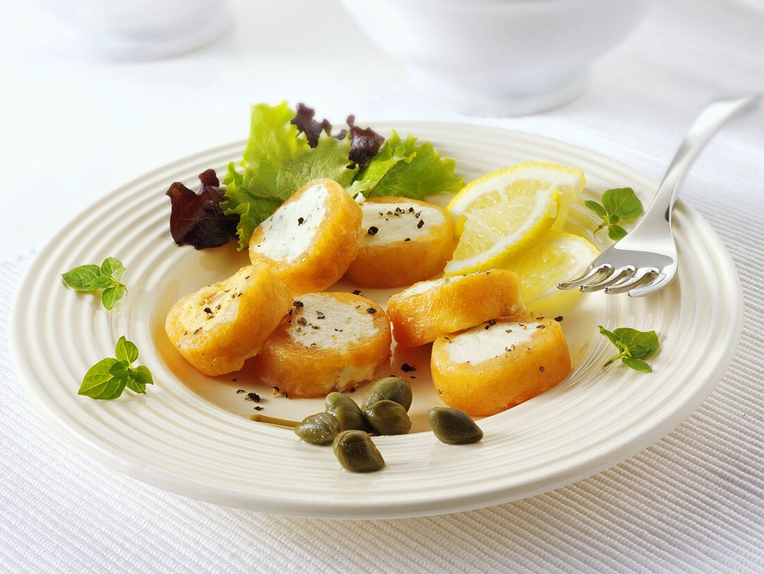 Gefüllte Lachsröllchen mit Zitronenschnitzen und Kapern