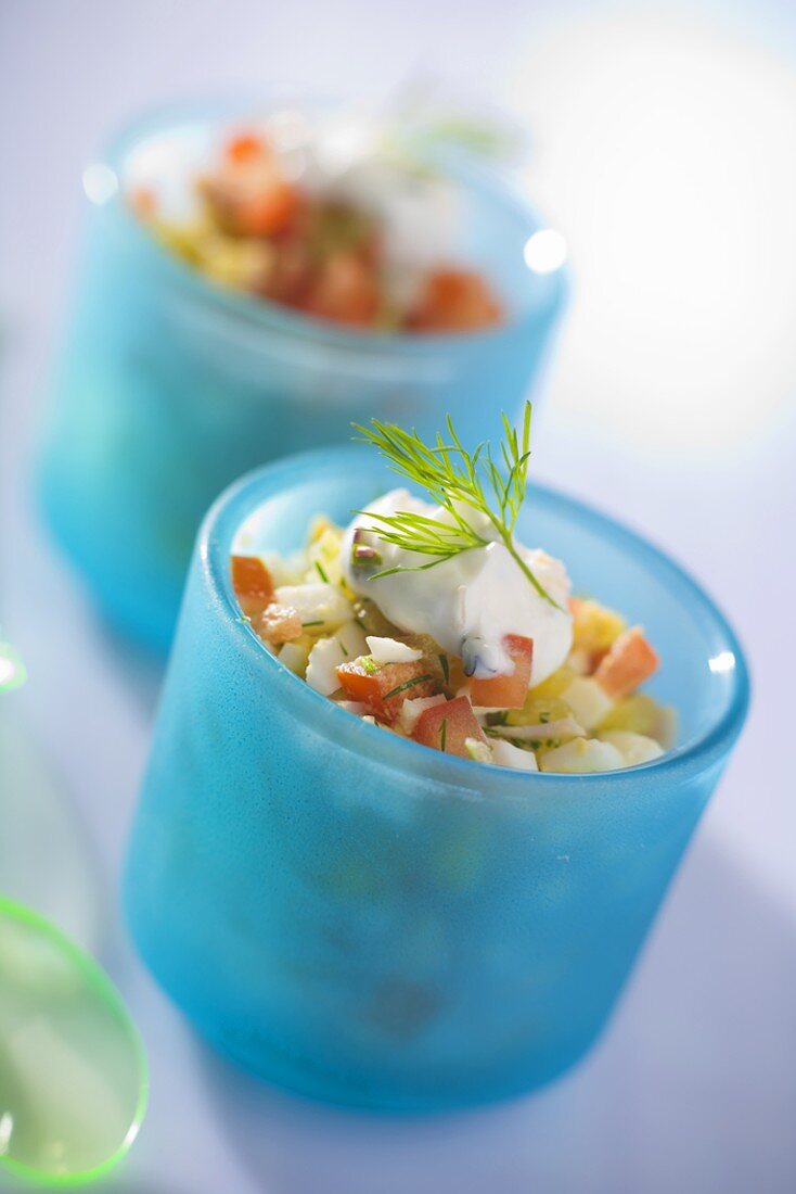 Vegetable salad with dill and yoghurt in blue glasses