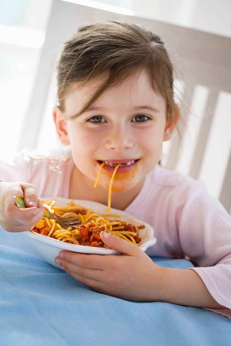 Girl eating spaghetti bolognese